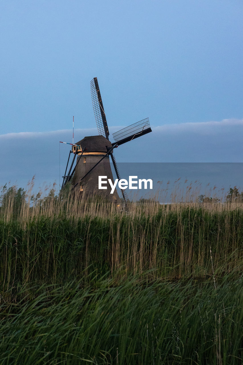 Beautiful wooden windmills at sunset in the dutch village of kinderdijk. windmills run on the wind.