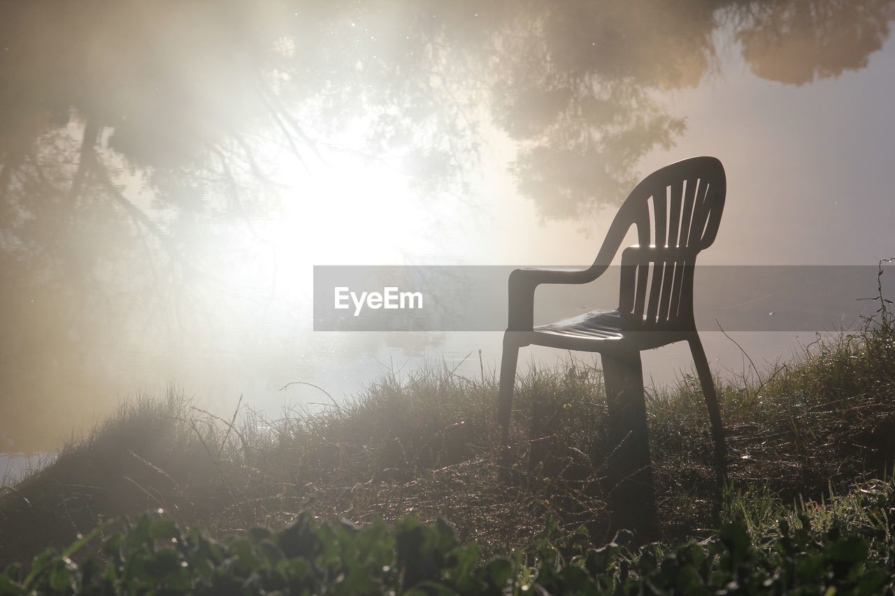 View of chair on landscape against sky