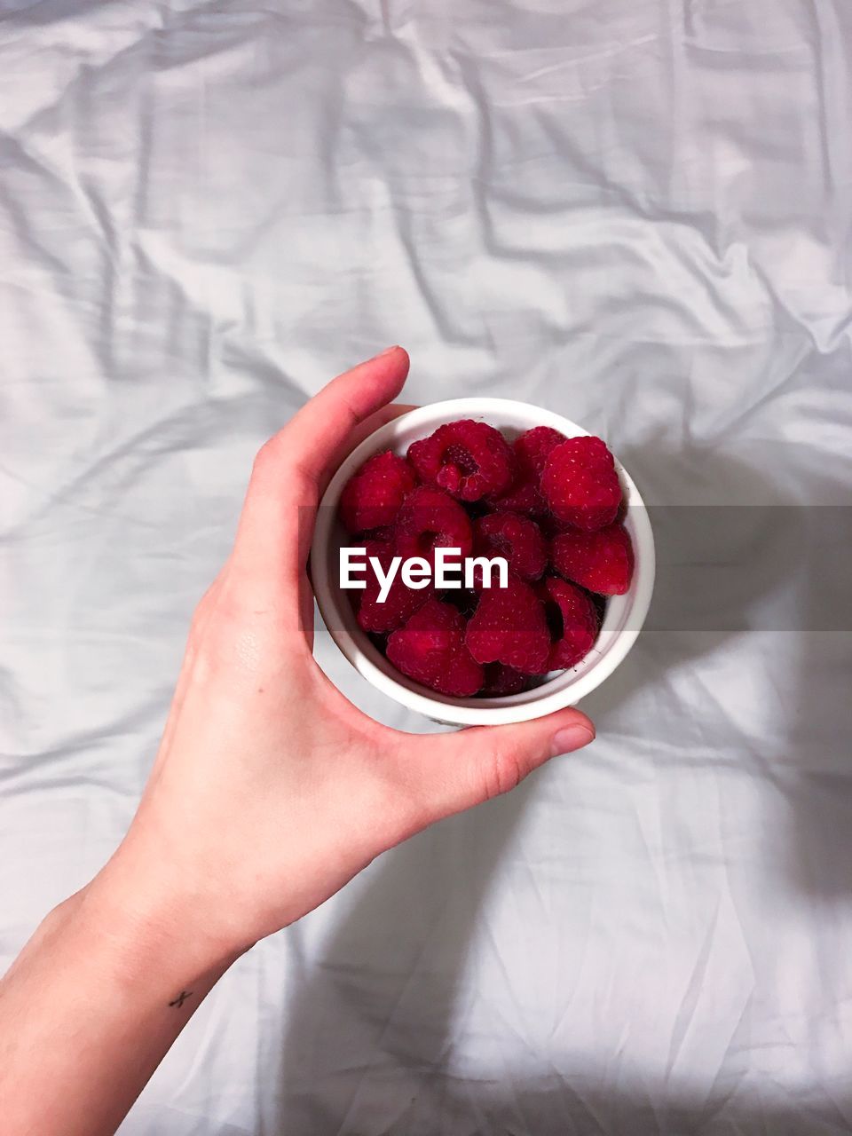 DIRECTLY ABOVE SHOT OF WOMAN HOLDING STRAWBERRY IN BOWL