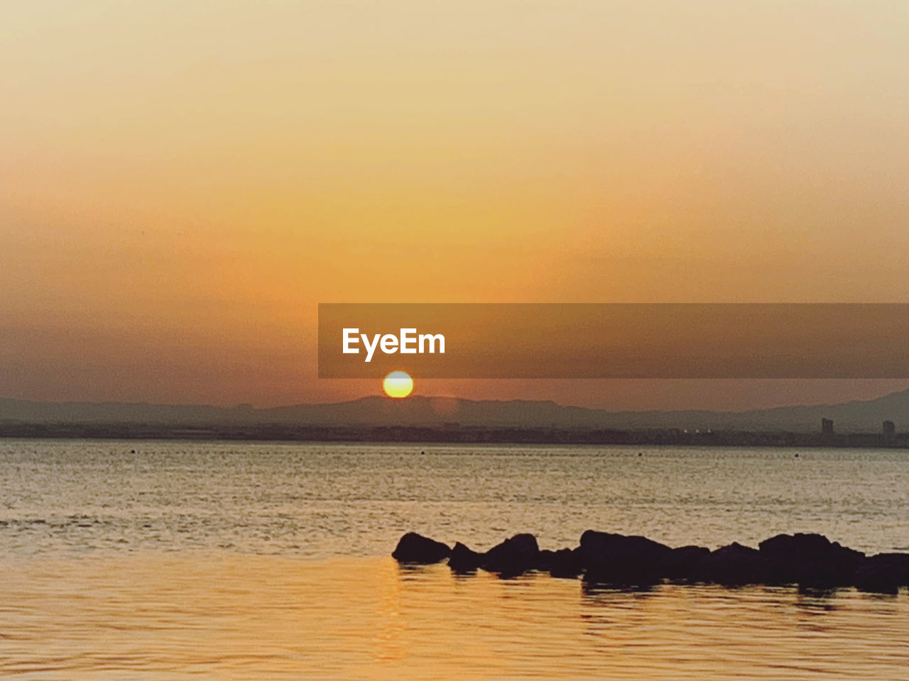 SCENIC VIEW OF SEA AGAINST ORANGE SKY DURING SUNSET