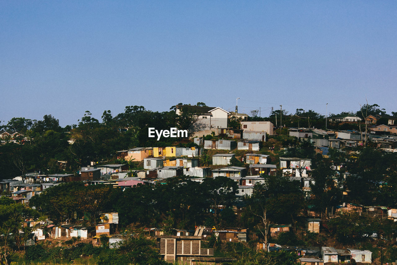 HIGH ANGLE VIEW OF RESIDENTIAL BUILDINGS AGAINST CLEAR SKY