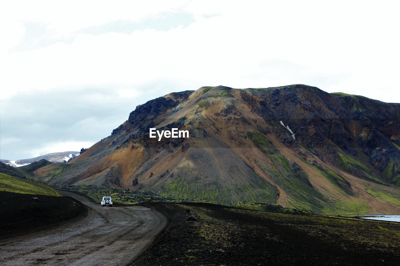 Road passing through mountains against sky