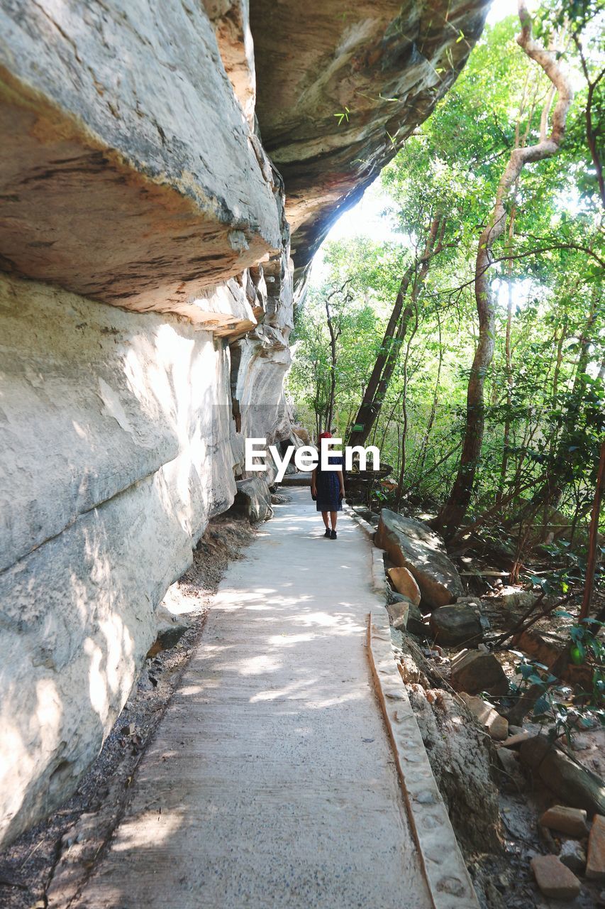 Woman walking by rocks in forest