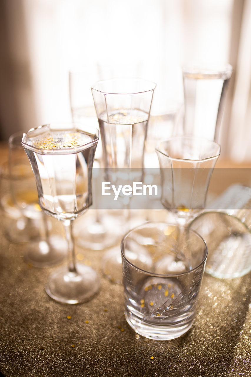 Close-up  champagne  glass with colorful glitter on table