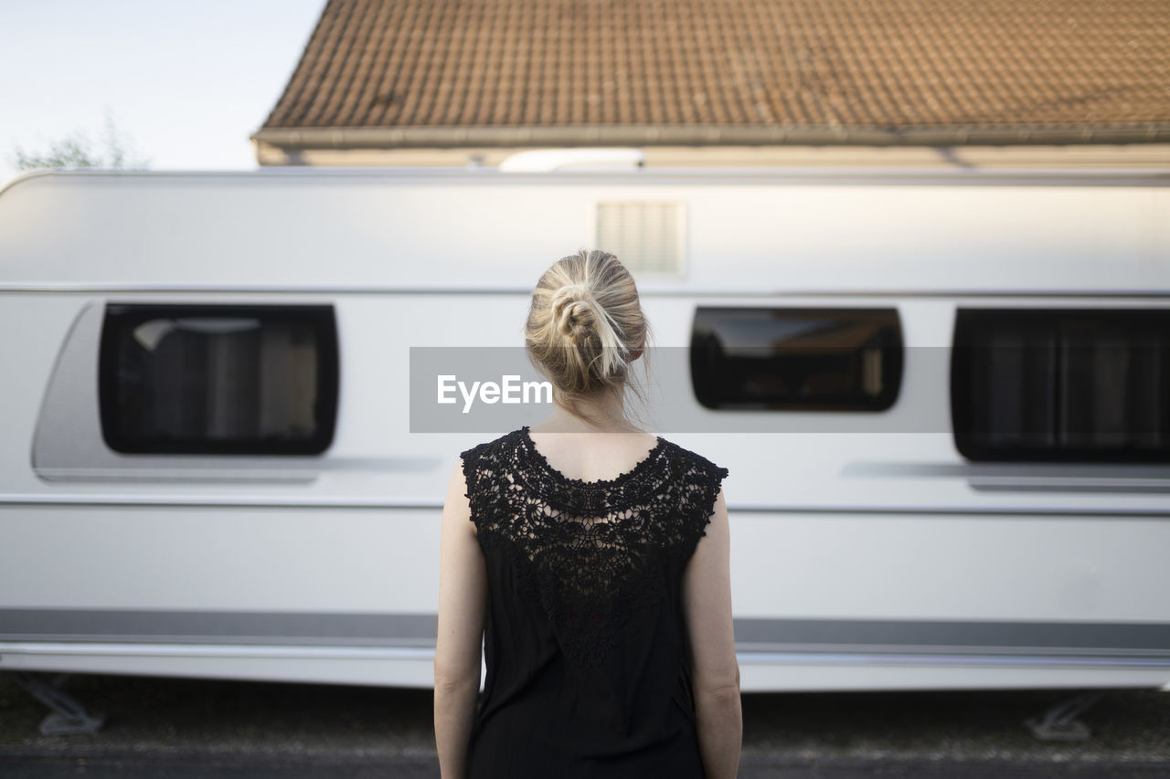 Blond woman in front of camper trailer