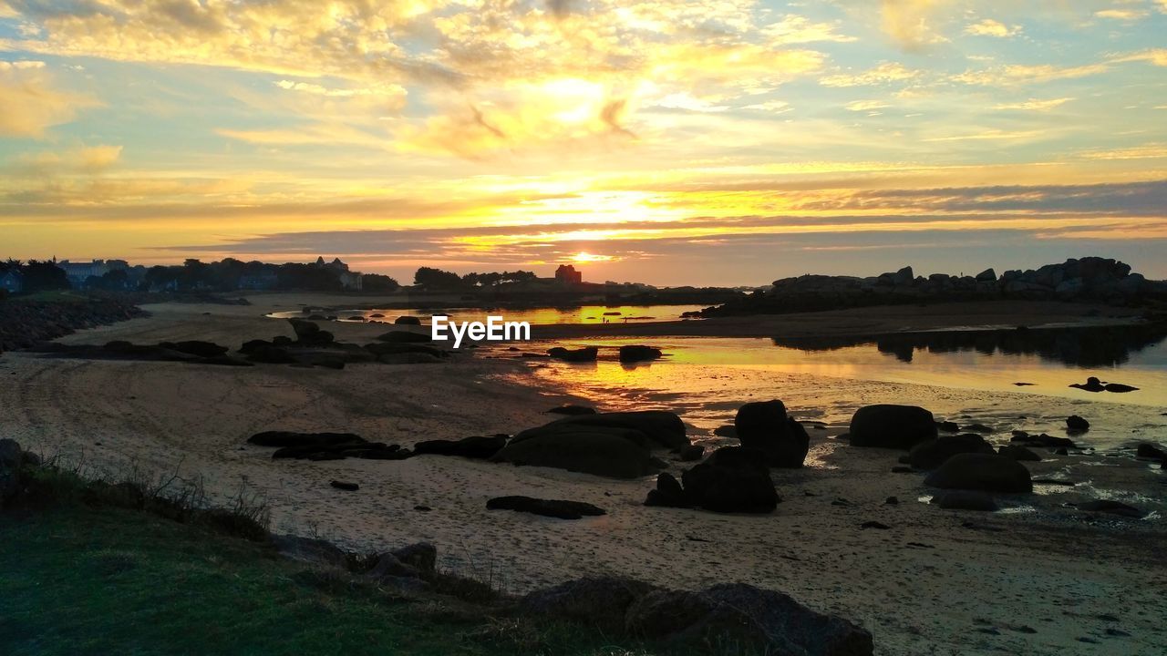 SCENIC VIEW OF BEACH AGAINST SKY AT SUNSET