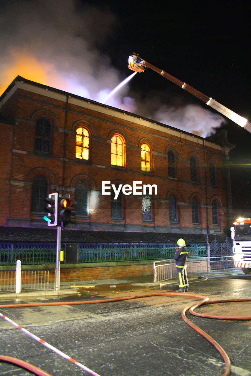 PERSON IN ILLUMINATED BUILDING AT NIGHT