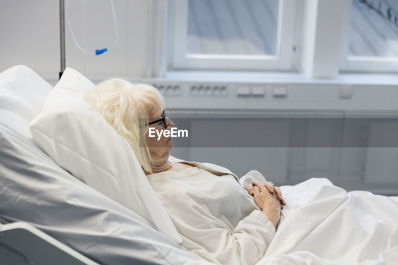 Senior woman lying in hospital bed
