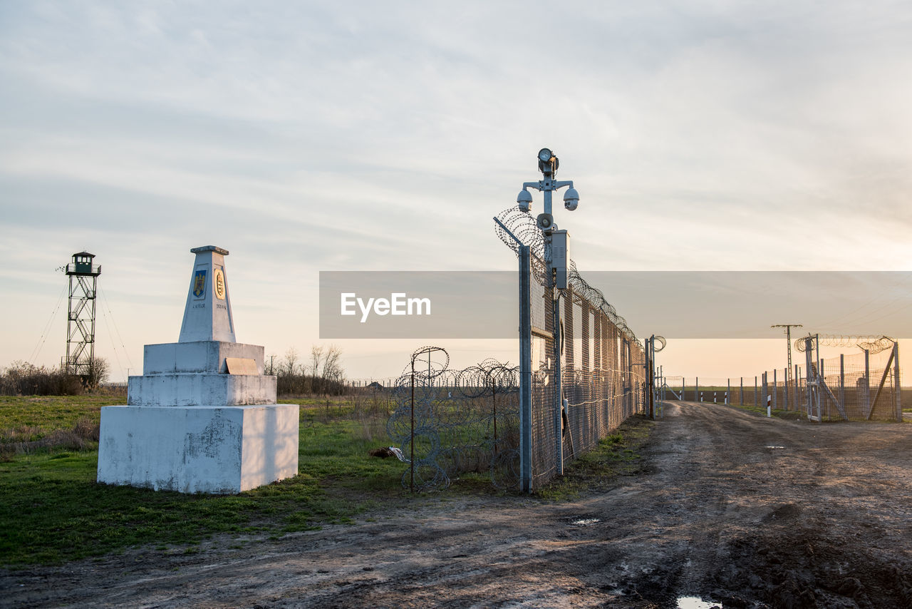 METAL STRUCTURE ON FIELD AGAINST SKY