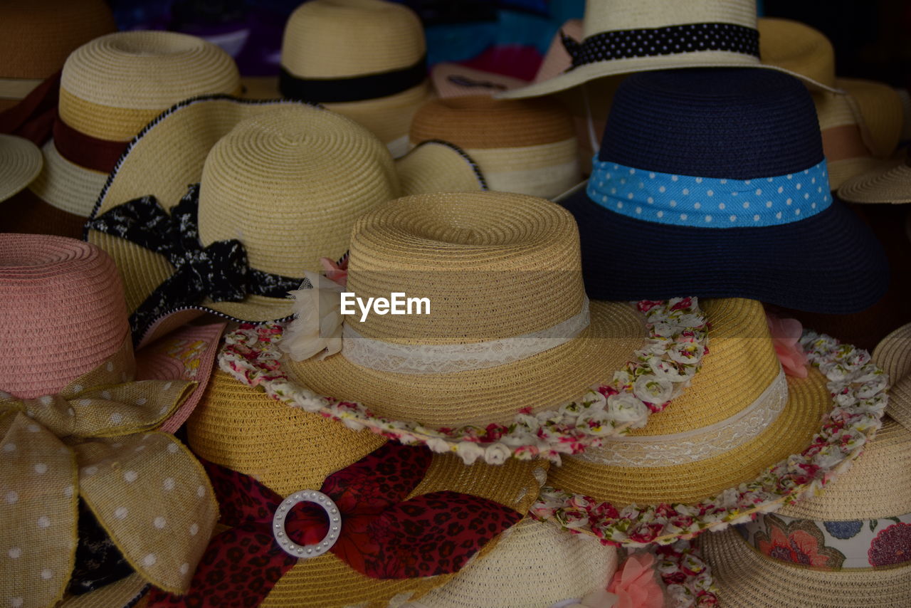 hat, clothing, retail, no people, fashion accessory, art, multi colored, crochet, for sale, variation, market, large group of objects, still life, textile, yellow, fashion, store, indoors, pattern, craft, straw hat