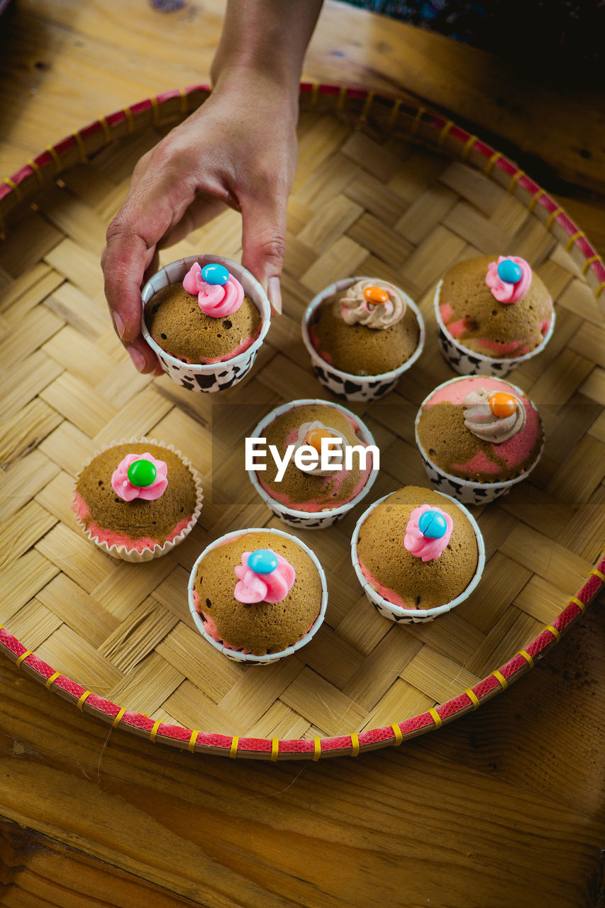 Cropped hand of woman with cake on table