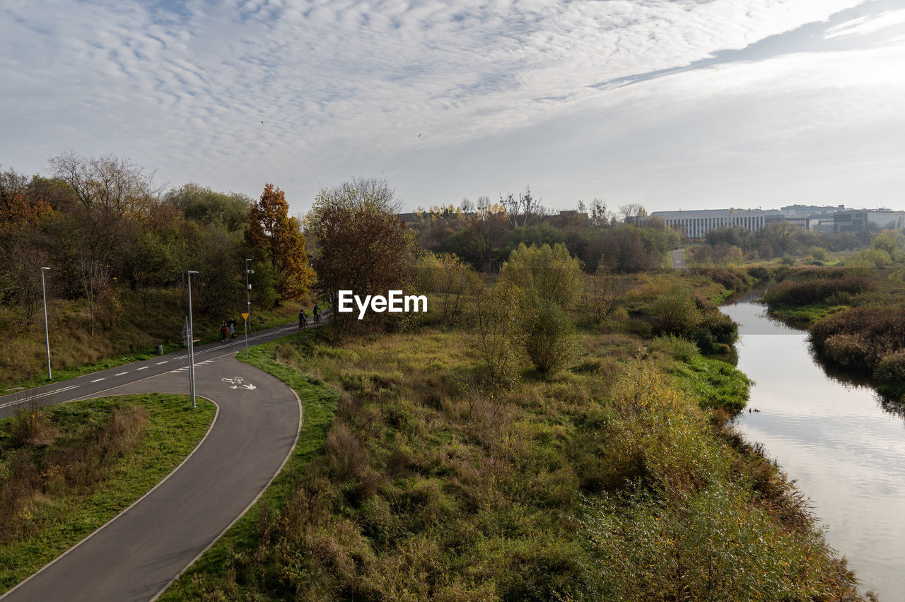 plant, tree, sky, nature, road, environment, landscape, river, rural area, transportation, water, scenics - nature, cloud, land, travel, beauty in nature, no people, hill, tranquility, outdoors, travel destinations, waterway, reservoir, non-urban scene, day, grass, tourism, tranquil scene, high angle view, curve, forest, infrastructure