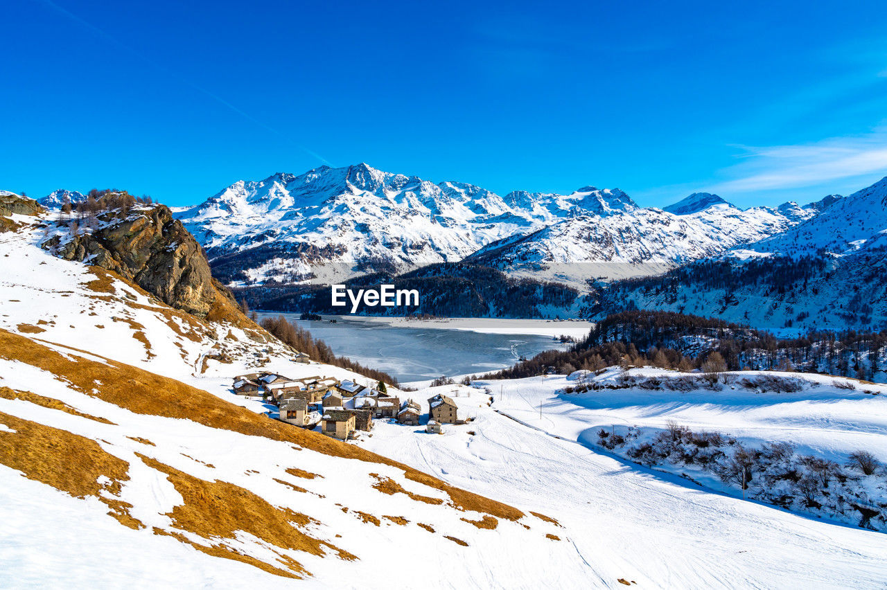 View of the village of grevasalvas, and lake sils, in engadine, switzerland, in winter.
