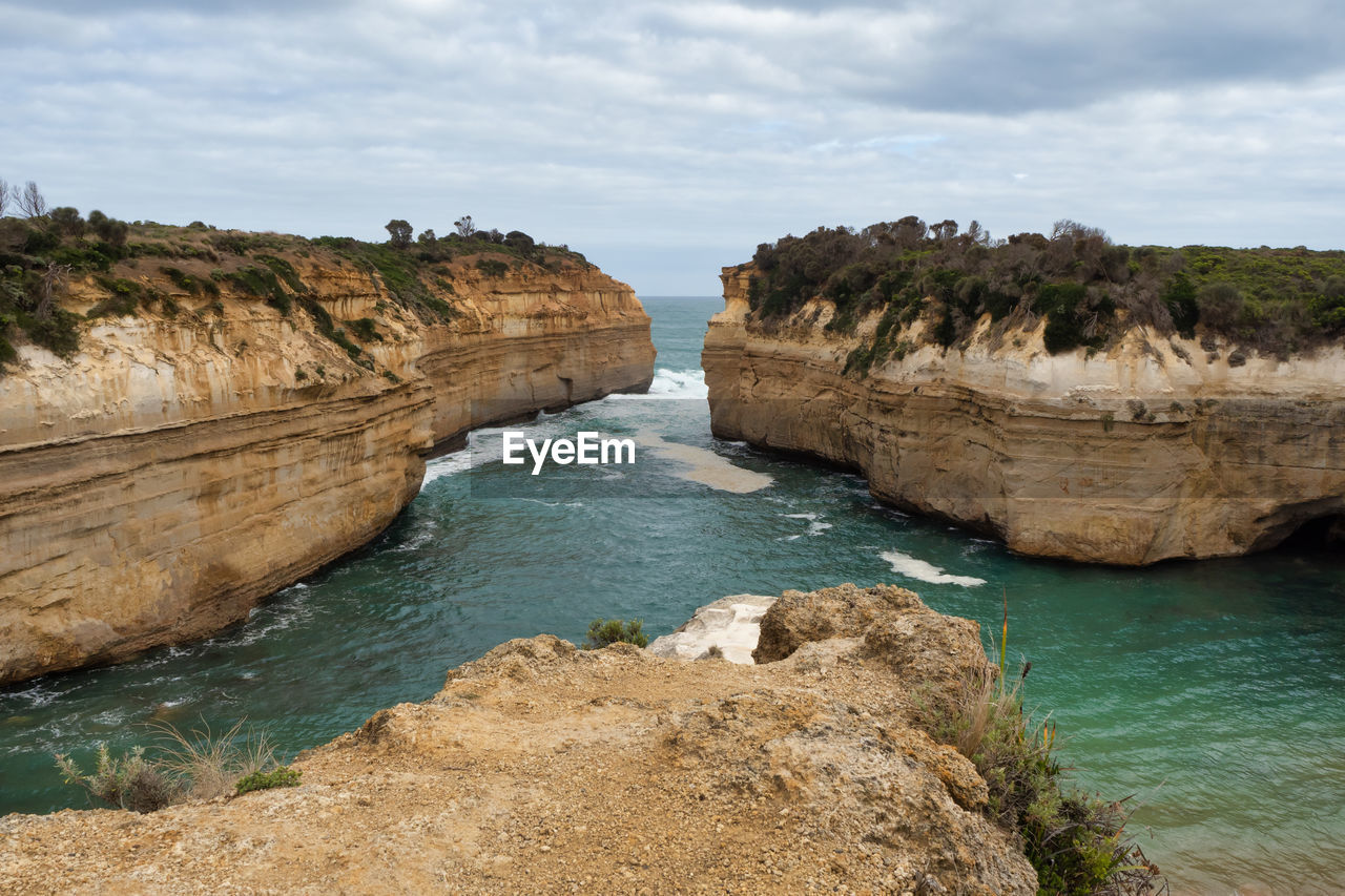 Rock formations by sea against sky