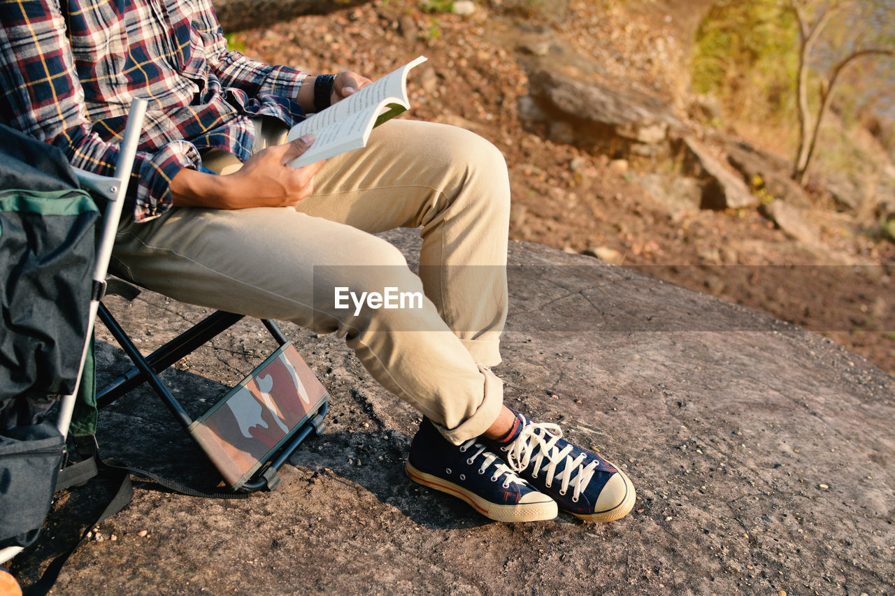 Low section of man sitting on asphalt