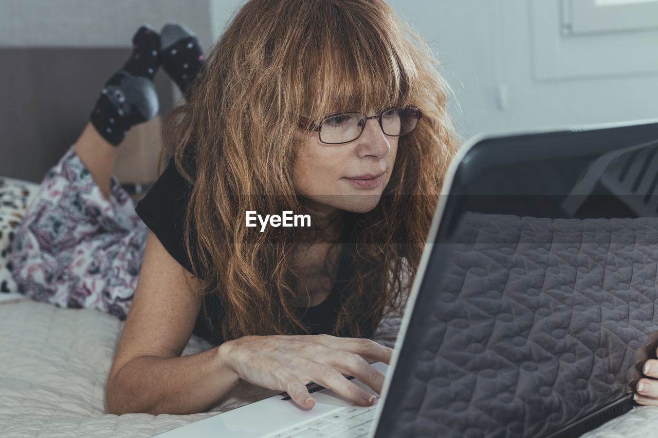 Adult woman with laptop in the room or bedroom