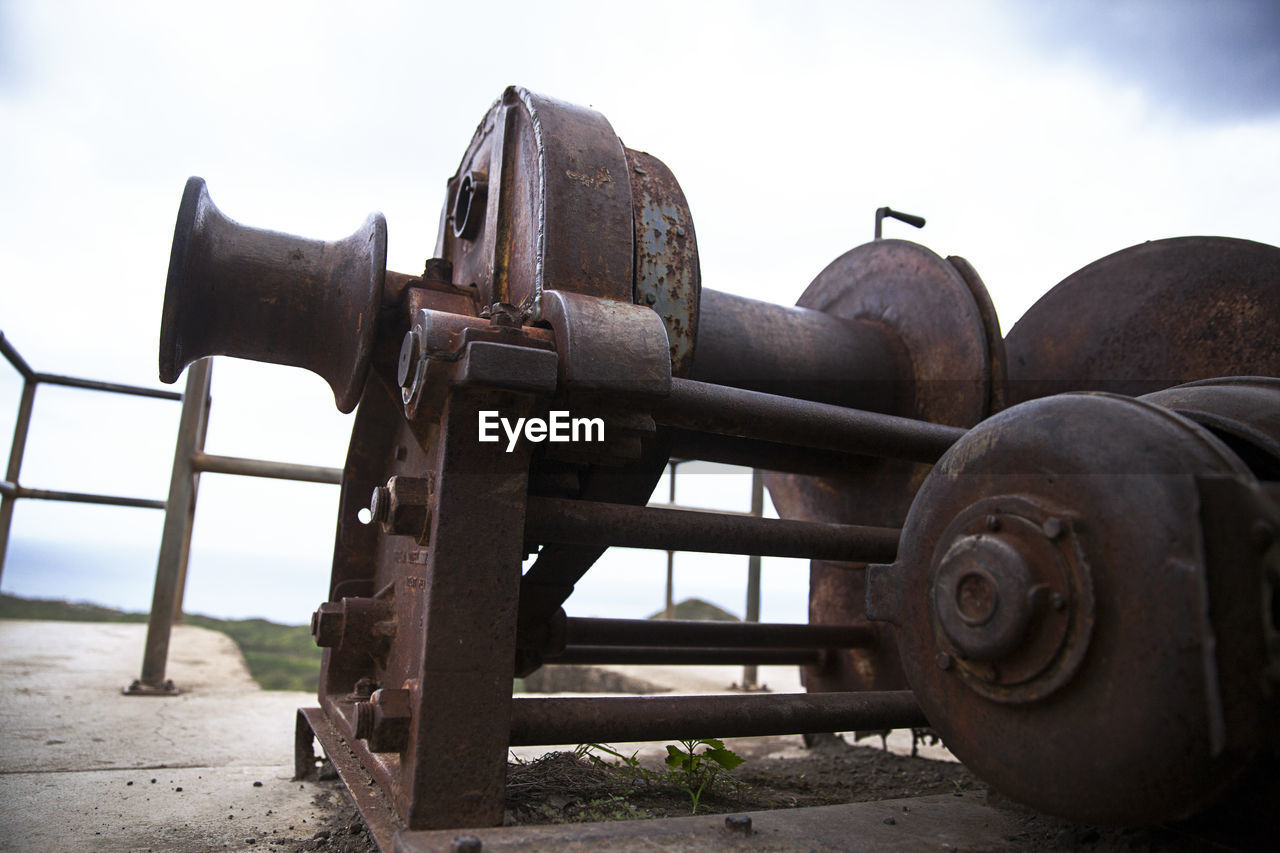 CLOSE-UP OF RUSTY MACHINE PART ON FIELD