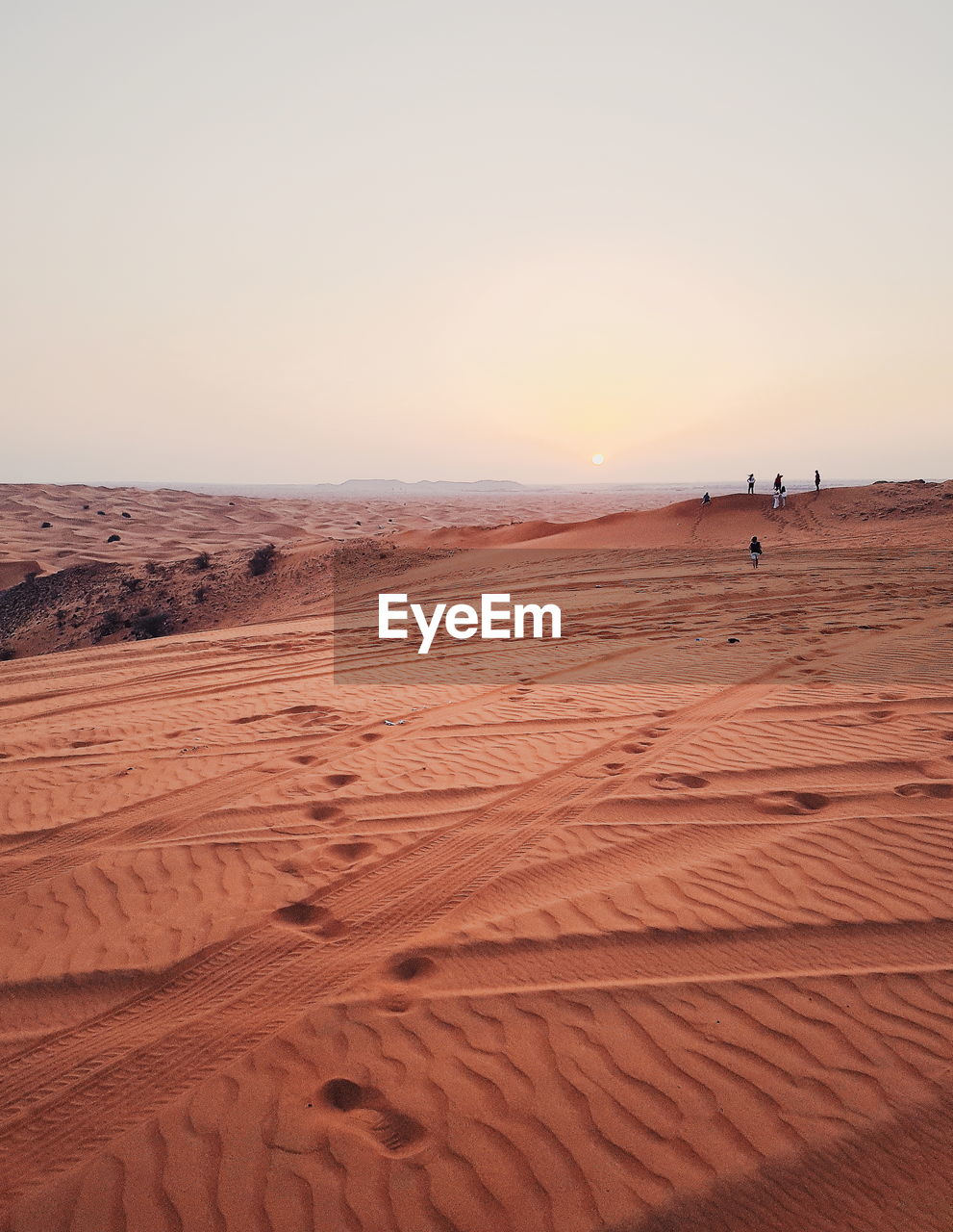 Scenic view of desert against clear sky during sunset