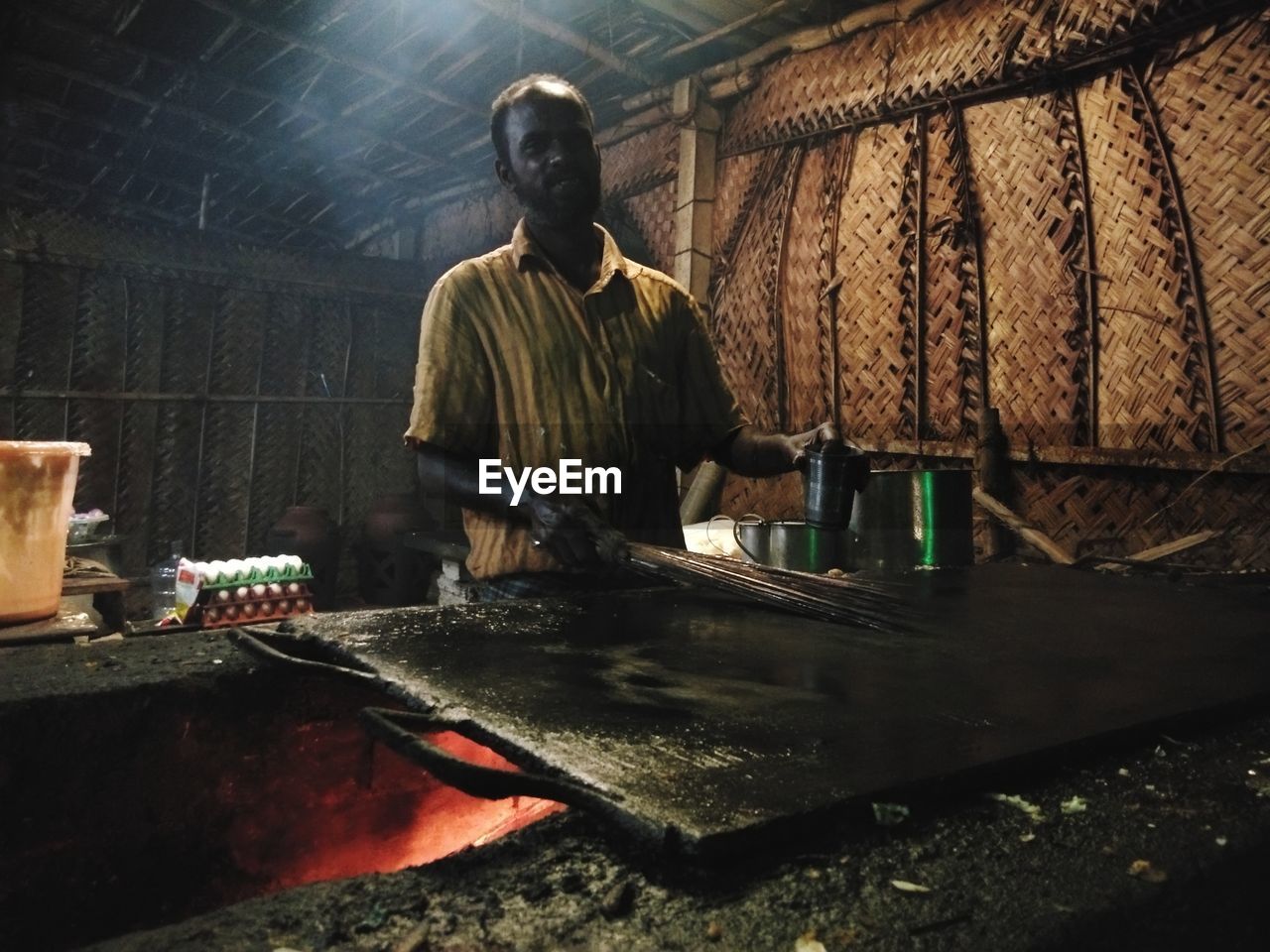 REAR VIEW OF MAN WORKING IN KITCHEN