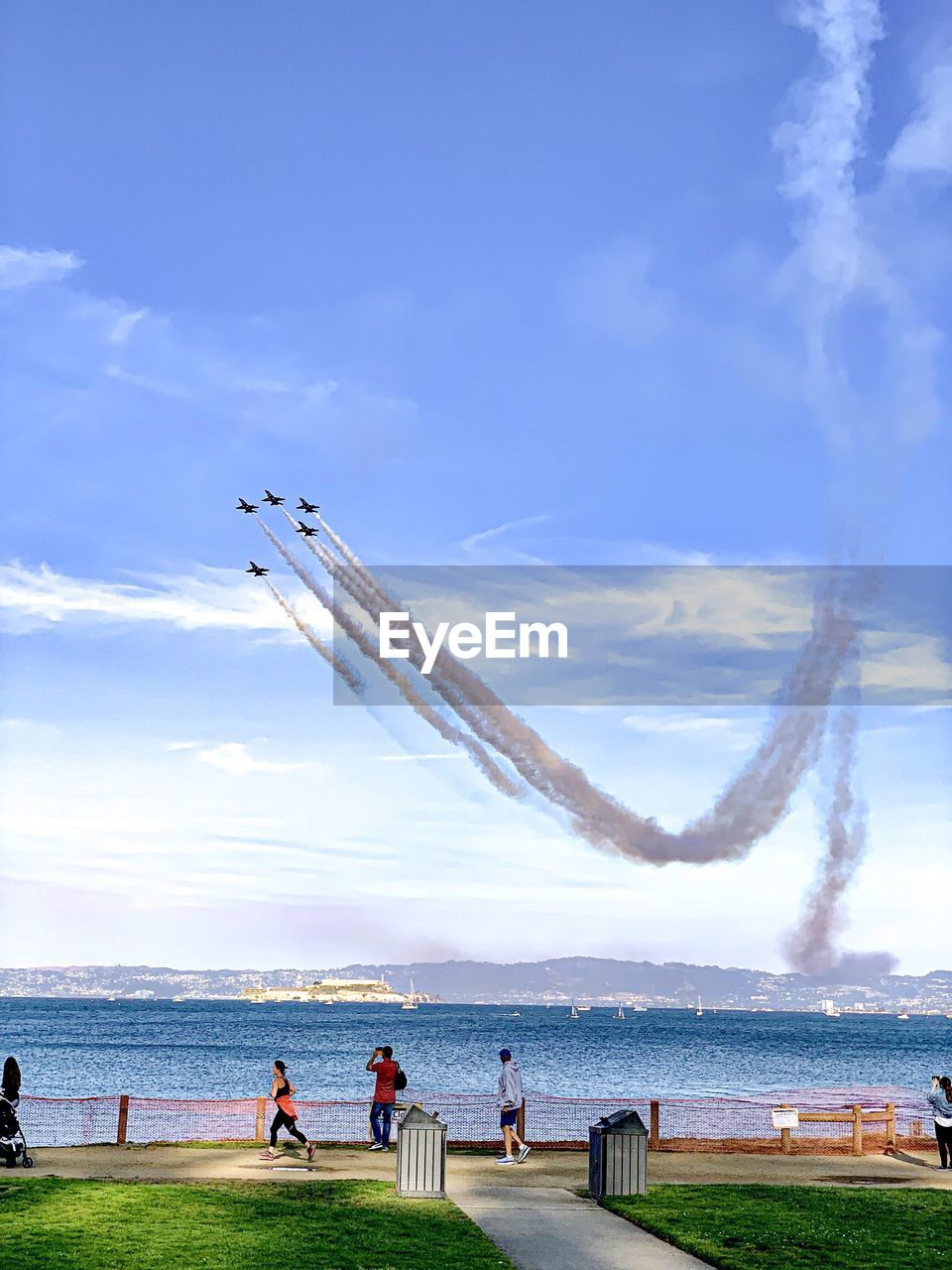 PEOPLE FLYING BY SEA AND AIRPLANE AGAINST SKY