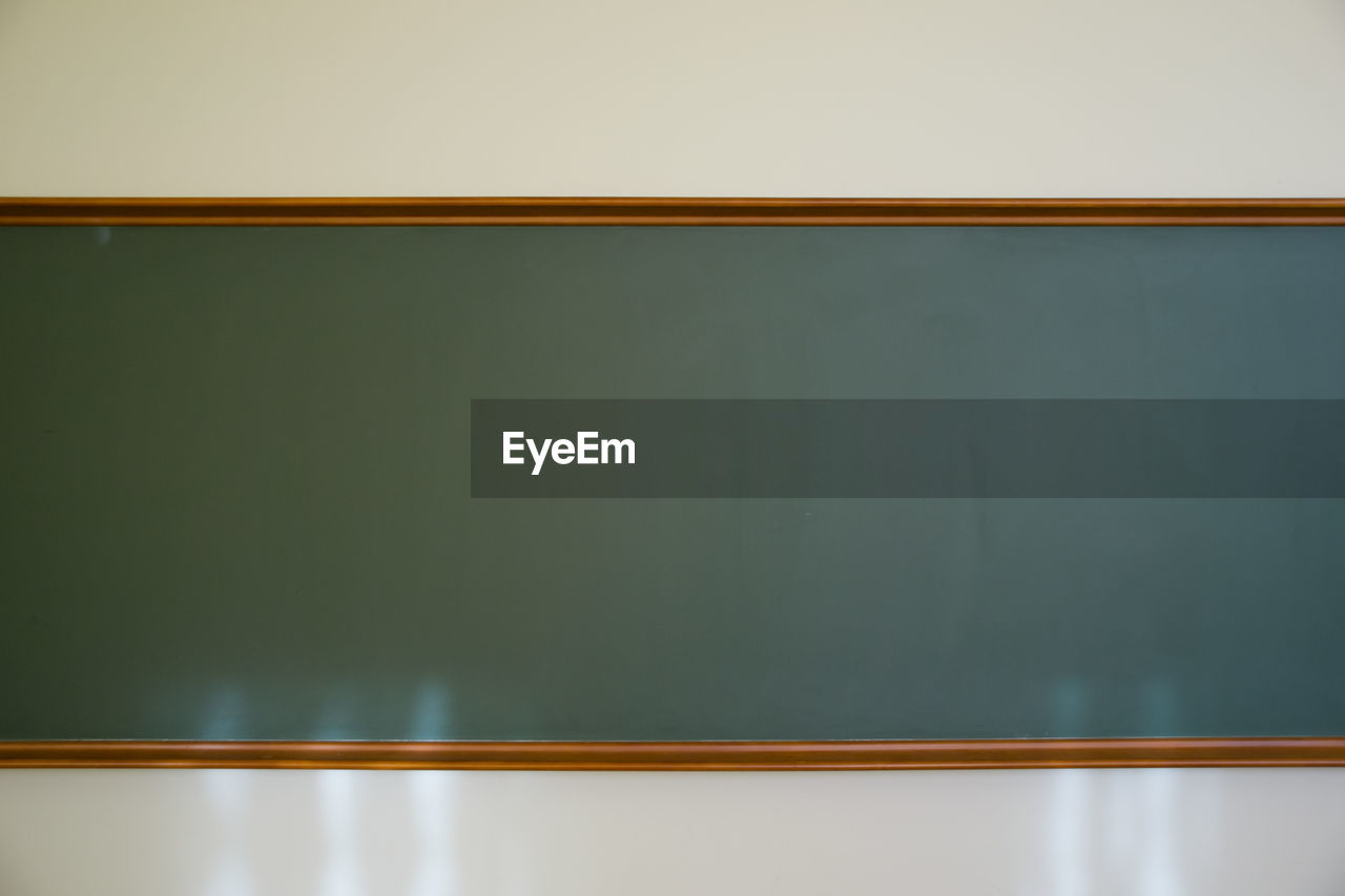 Vintage chalkboard in wooden frame on white wall