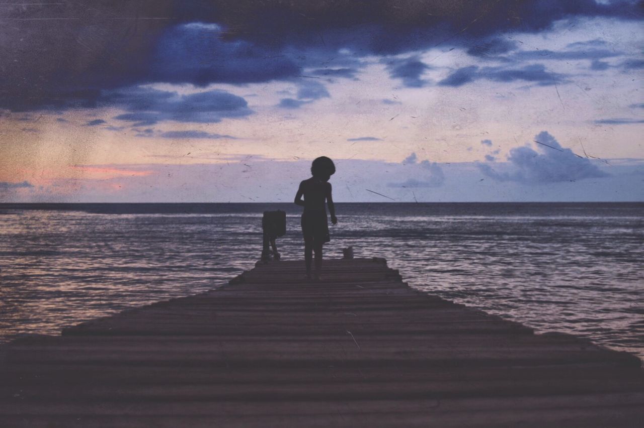 Rear view of silhouette man standing on beach