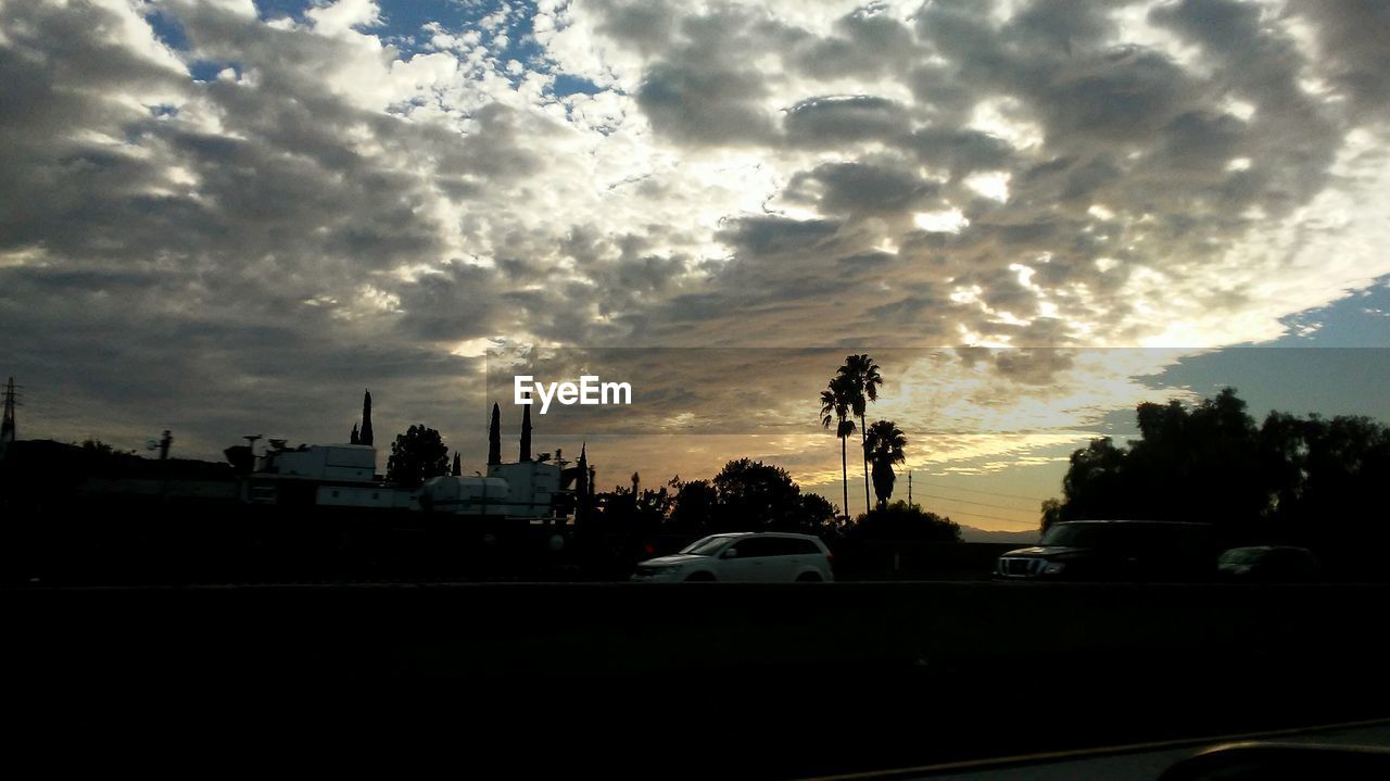 Silhouette of road against cloudy sky