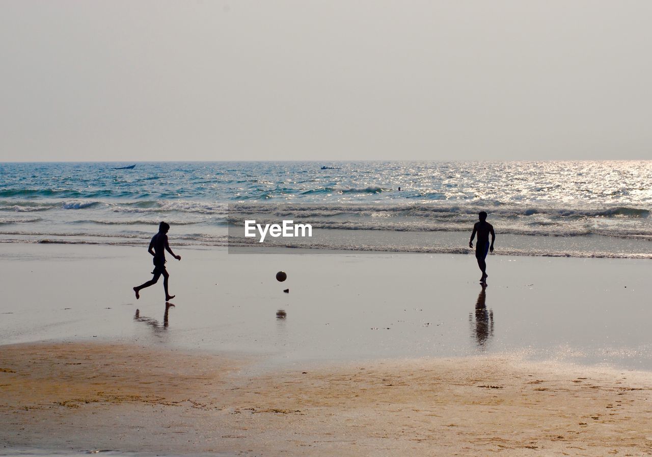 FULL LENGTH OF MAN AT BEACH AGAINST SKY