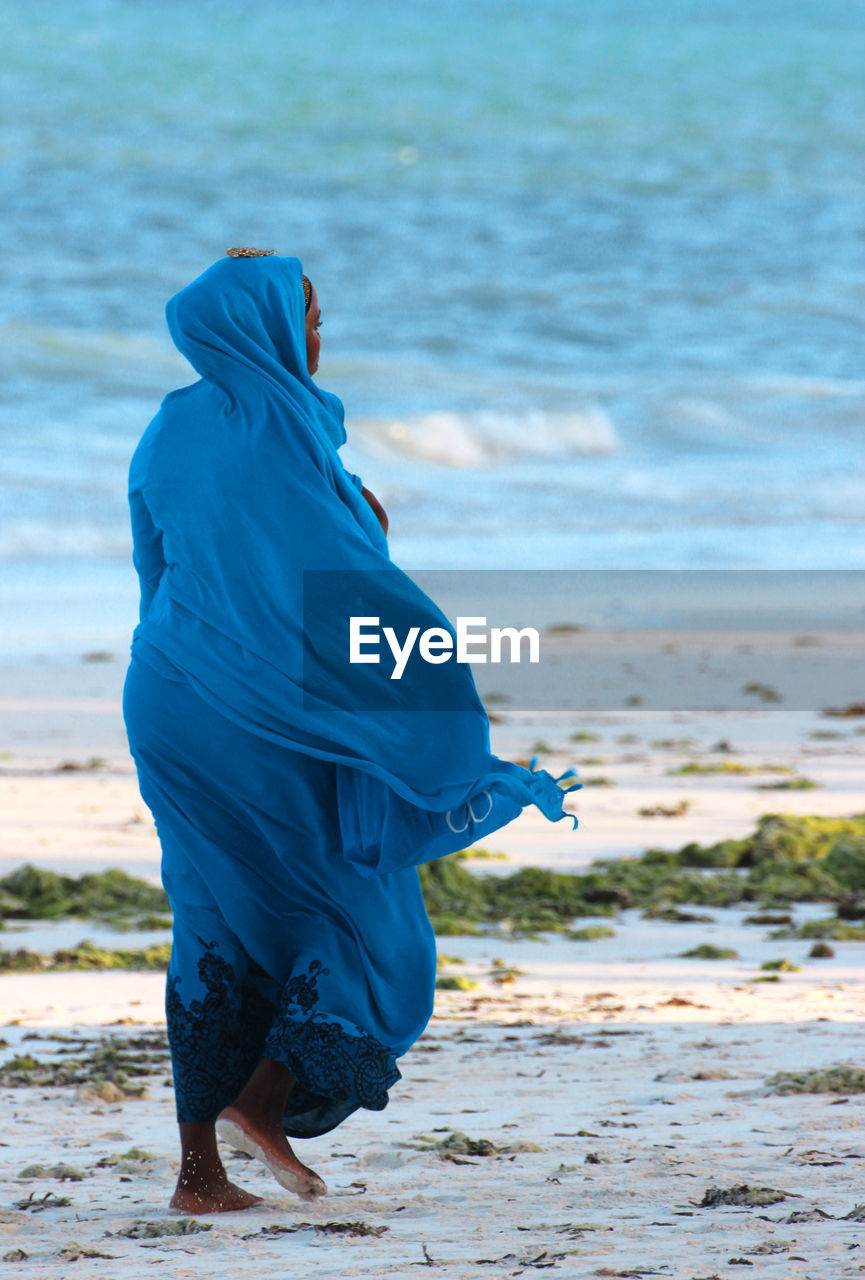 Full length of woman walking on sand at beach