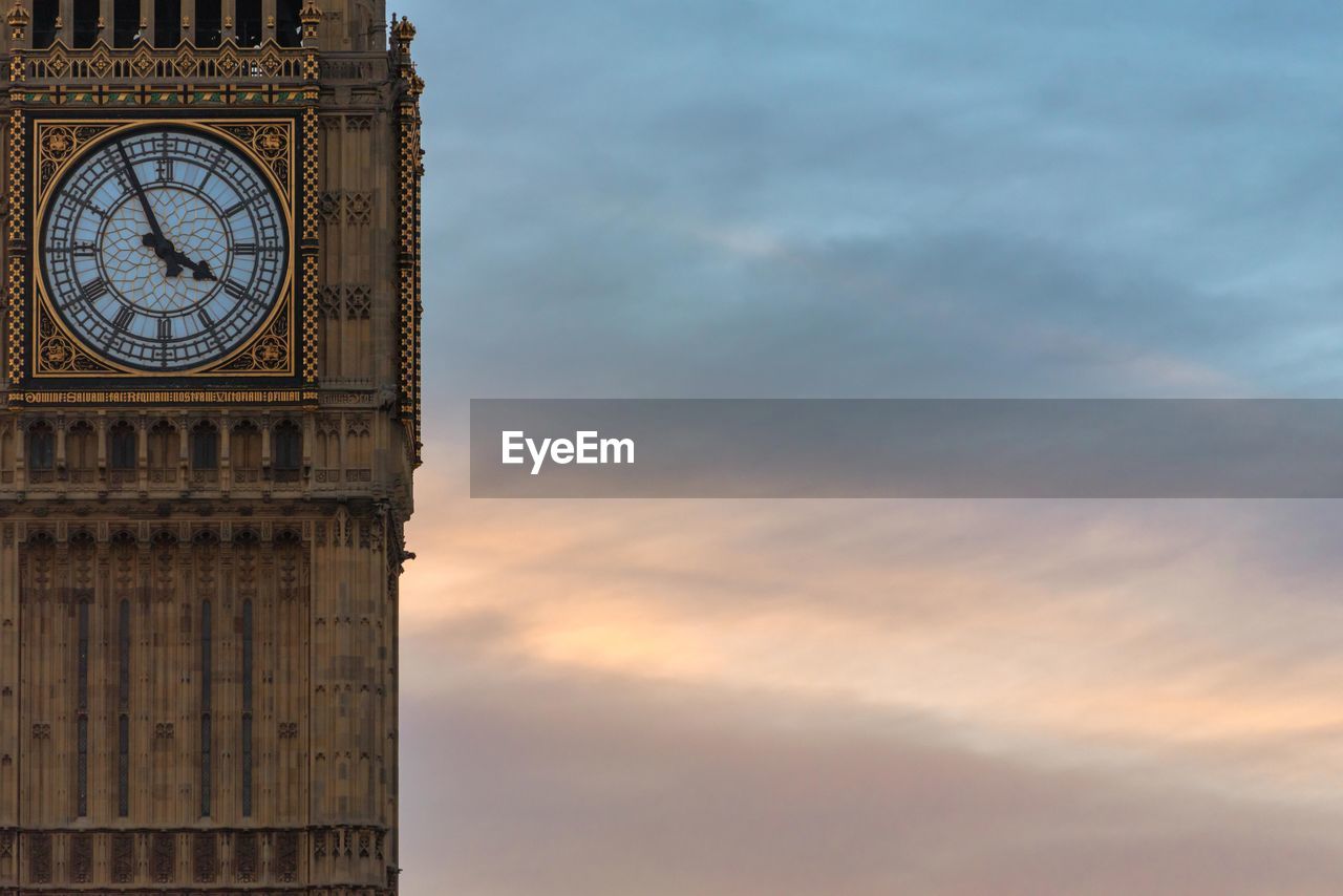 Clock tower against cloudy sky during sunset