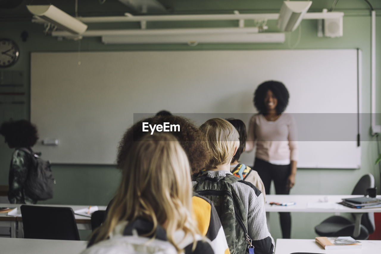 Multiracial students walking in queue while leaving classroom