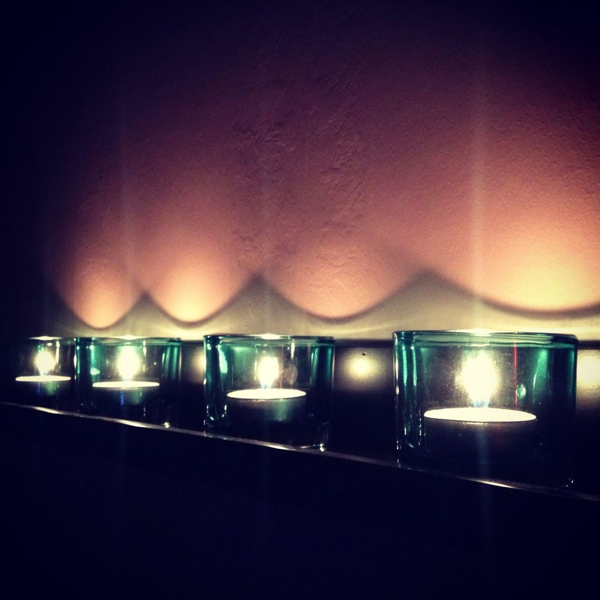 Close-up of illuminated candles against wall