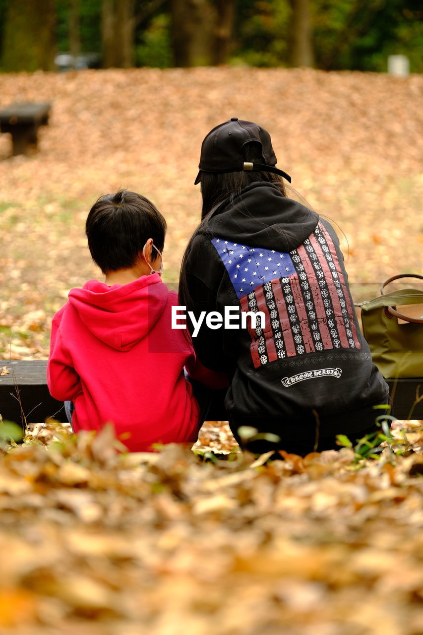 REAR VIEW OF COUPLE SITTING ON FLOOR