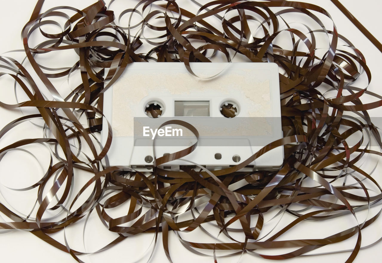 Close-up of electrical equipment and reel over white background