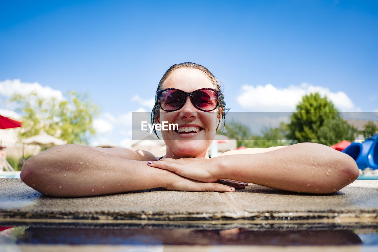Smiling woman in a pool on a hot summer day