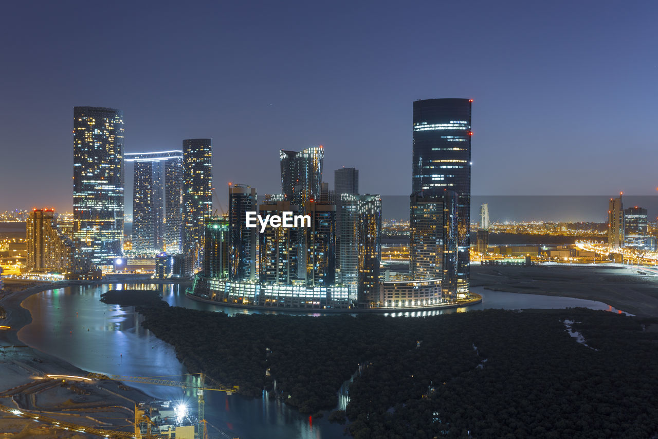 ILLUMINATED MODERN BUILDINGS IN CITY AT NIGHT