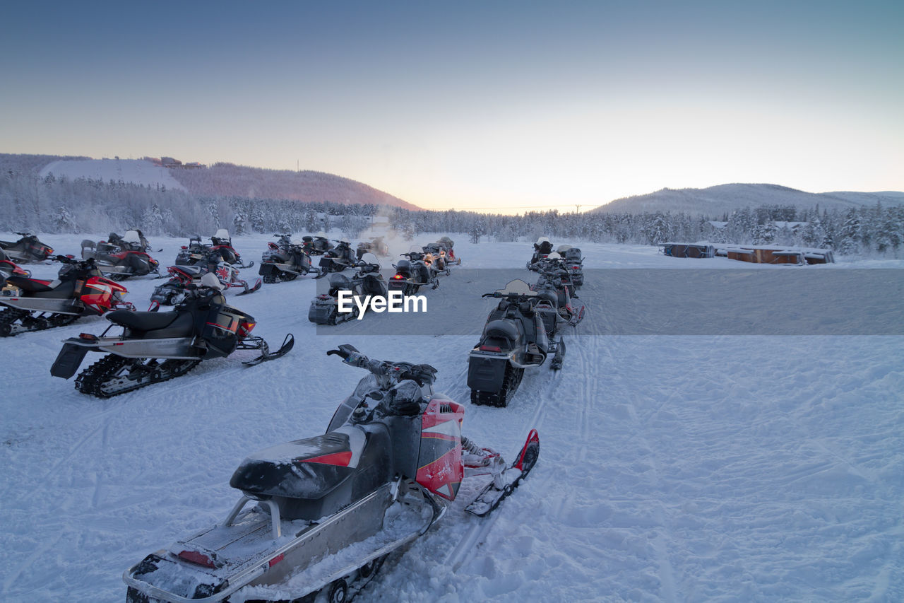 Group of snowmobiles ready for a ride in lapland countryside