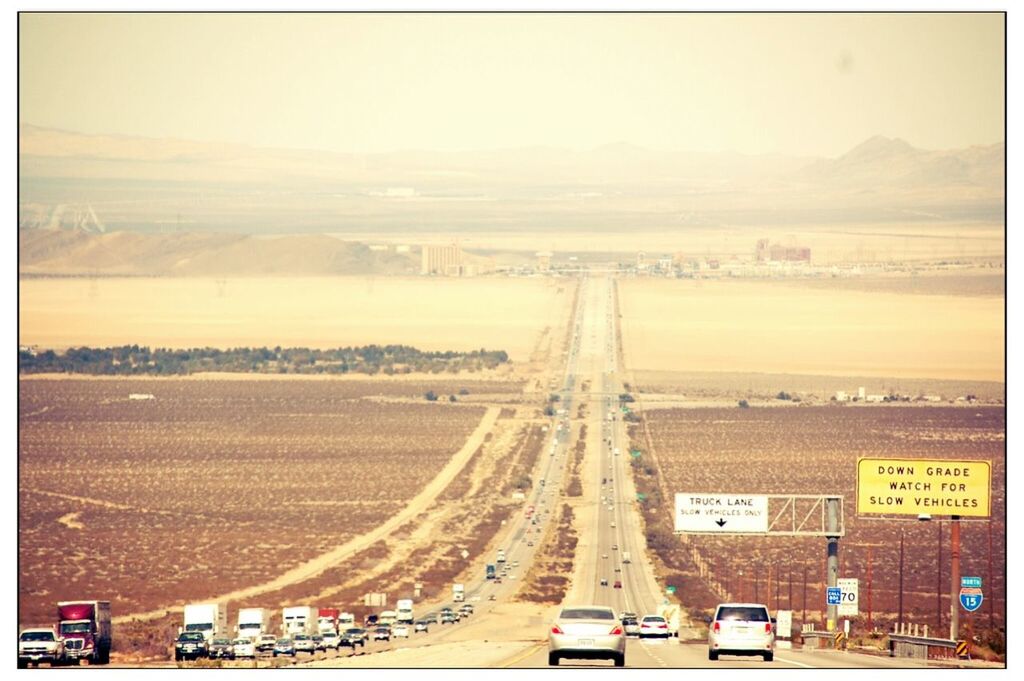 Vehicles moving on road amidst field