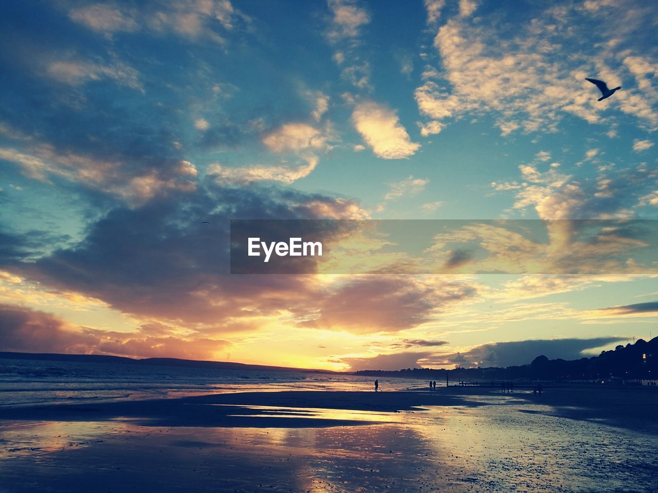 Scenic view of beach against dramatic sky