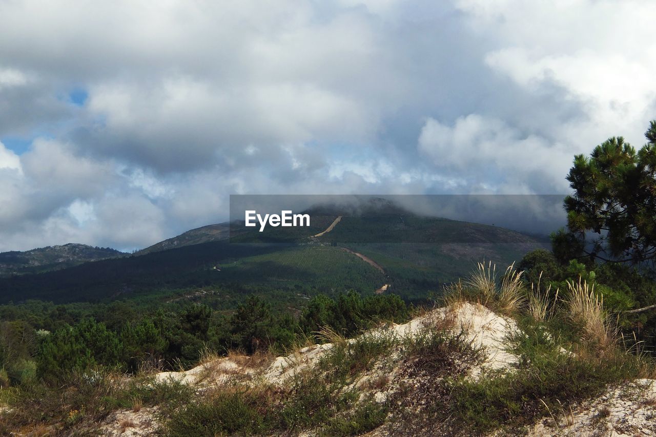 Scenic view of mountain against cloudy sky