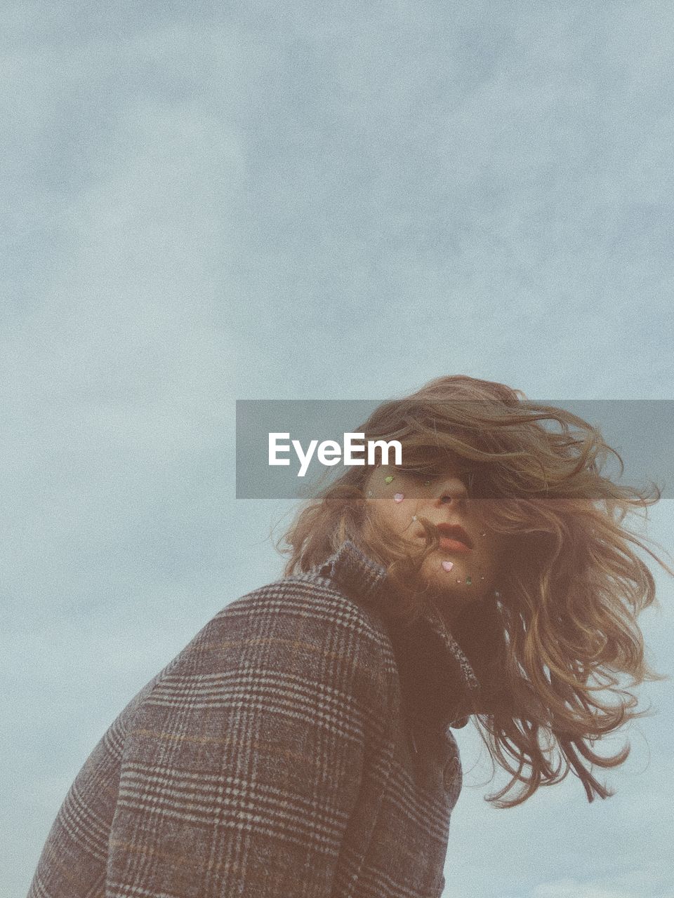 Low angle view of woman looking away against sky