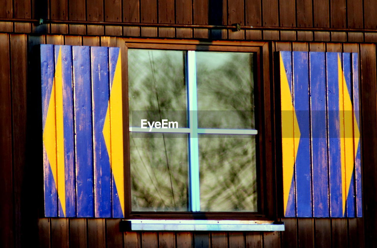 CLOSE-UP OF GLASS WINDOW WITH MULTI COLORED BUILDING