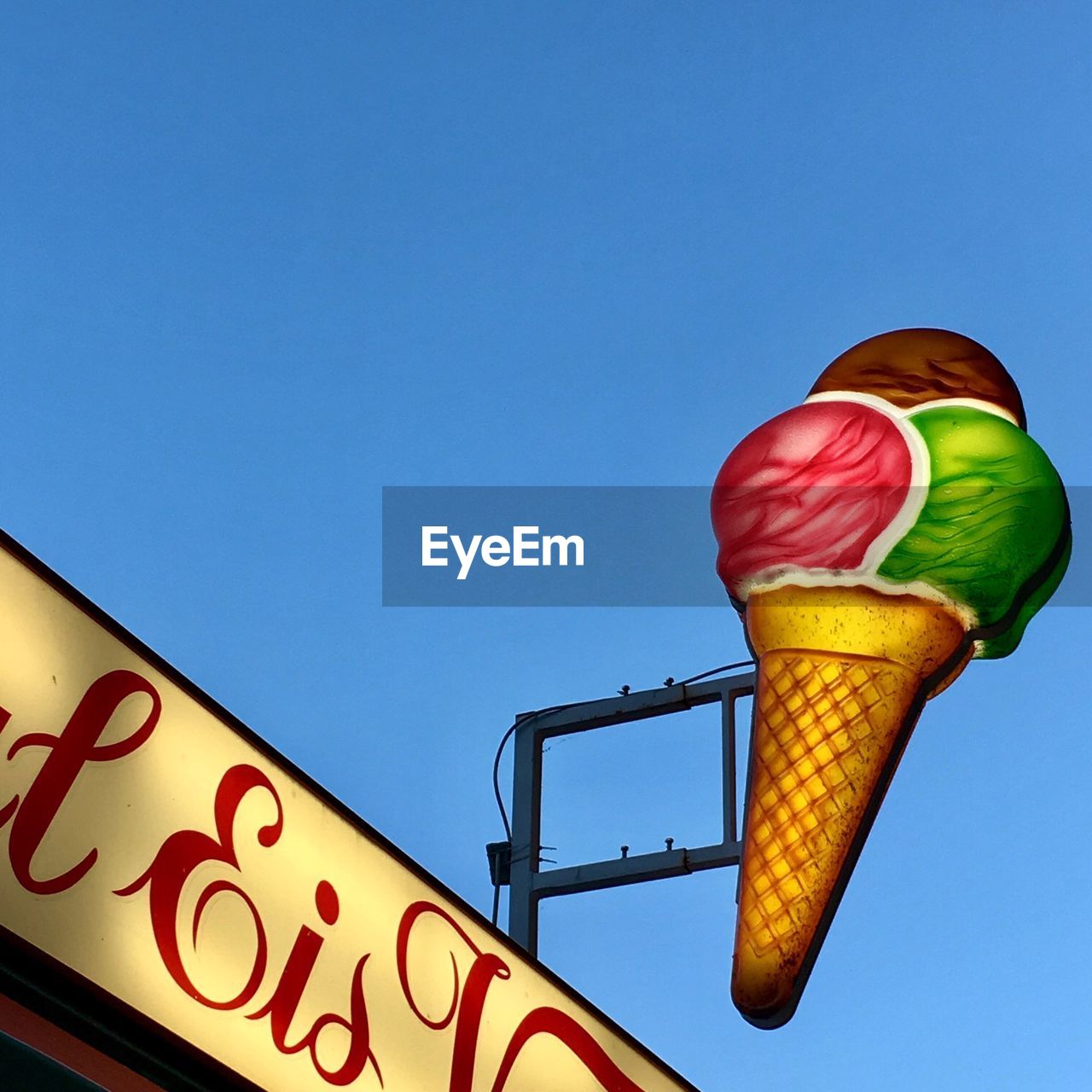 LOW ANGLE VIEW OF ROAD SIGNS AGAINST BLUE SKY