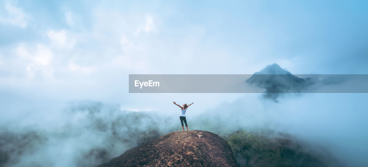 rear view of man walking on mountain against sky