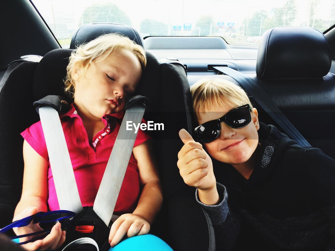 Portrait of boy wearing sunglasses with sister in car