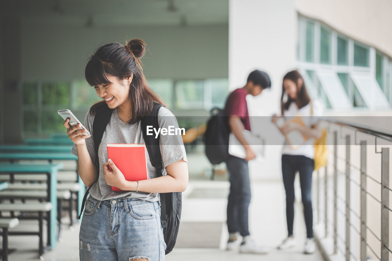 YOUNG WOMAN USING MOBILE PHONE IN CITY