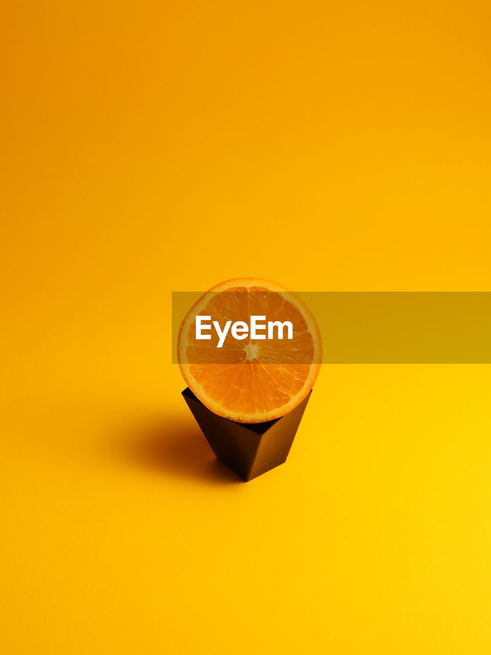 Close-up of orange fruit against yellow background