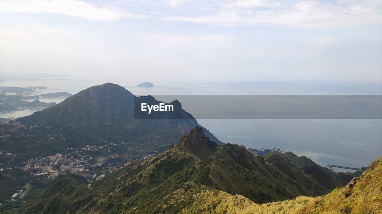 Scenic view of sea and mountains against sky