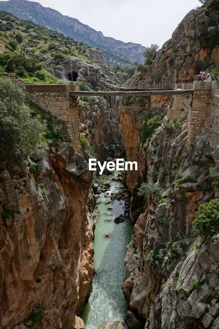 VIEW OF BRIDGE OVER RIVER AGAINST MOUNTAIN
