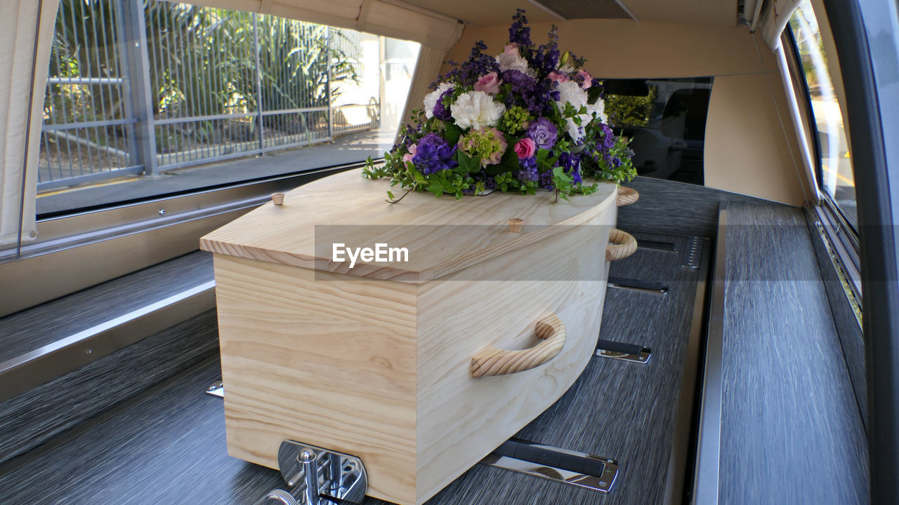 Closeup shot of a funeral casket or coffin in a hearse or chapel or burial at cemetery
